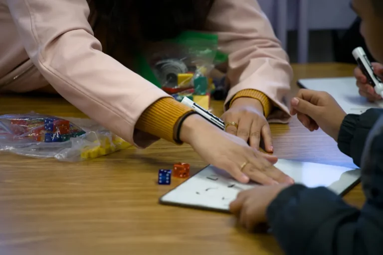 A Rufino Mendoza Elementary teacher uses her hand to wipe a dry-erase board after a student answered a math question on Jan. 20, 2024. (Jacob Sanchez | Fort Worth Report)