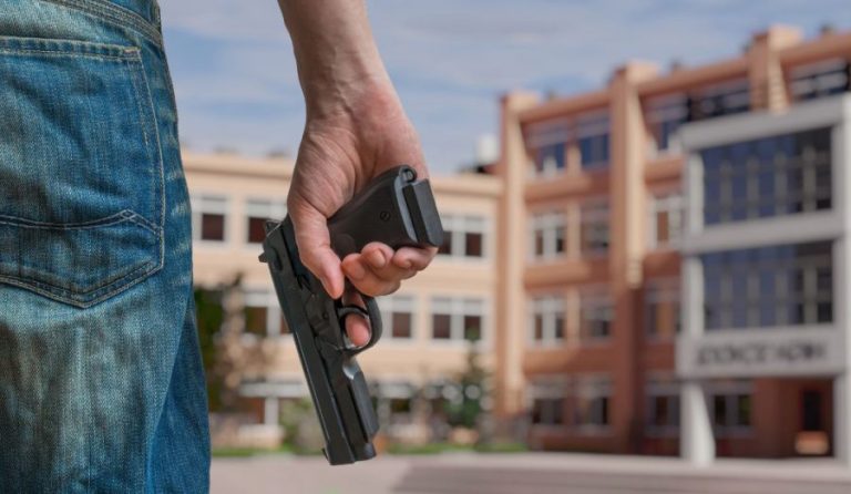 Person holding firearm near high school | Image by vchal/Shutterstock