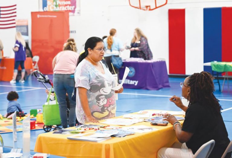 Sandlin George, an Army spouse, receives information from the Workforce Solutions table about job placement on Sept. 6, 2024, at the Homeschool Resource Fair at Bronco Youth Center at Fort Cavazos, Texas. (Photo Credit: Photo by Derika Upshaw, Fort Cavazos Public Affairs)