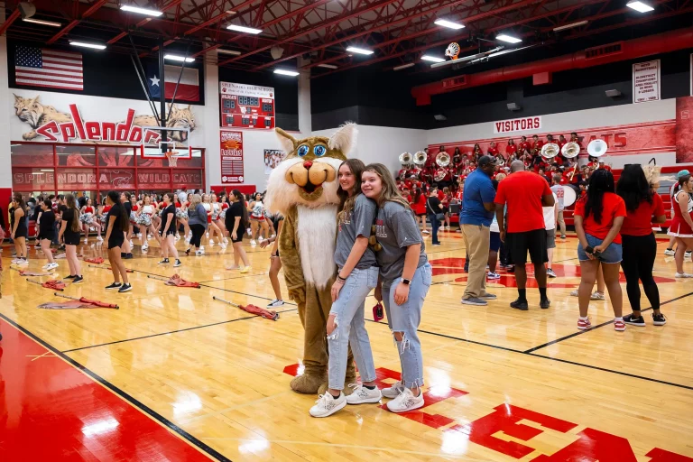 A mascot poses with students during the "Meet the Wildcats" community event at Splendora High School on Aug. 16, 2024, in Splendora. Credit: Annie Mulligan for The Texas Tribune