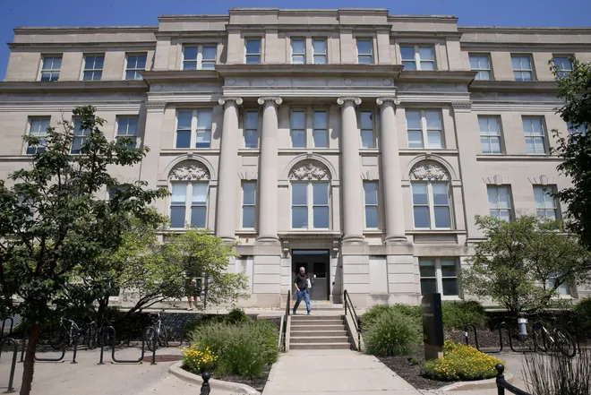 A person walks in front of Schaeffer Hall on the University of Iowa campus Wednesday, July 31, 2024 in Iowa City, Iowa. Julia Hansen/Iowa City Press-Citizen