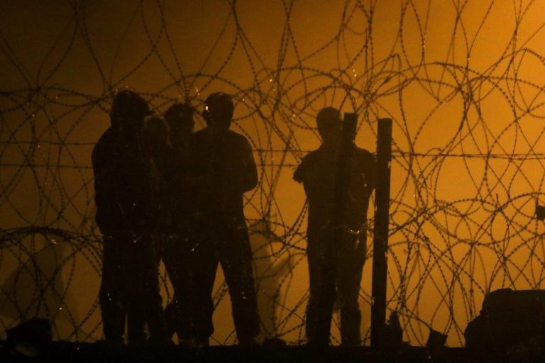 Migrants wait throughout the night on May 10, 2023, in a dust storm between the Rio Grande and the border wall, hoping they will be processed by immigration authorities. Oklahoma's state superintendent filed a lawsuit Tuesday against three federal agencies that oversee immigration enforcement. (Photo by Corrie Boudreaux/For Source NM)